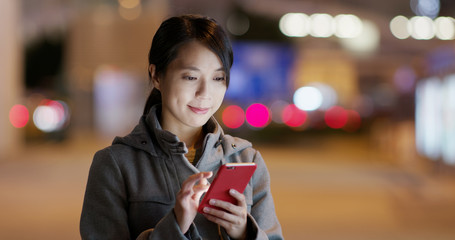 Tourist search on cellphone in the street at night