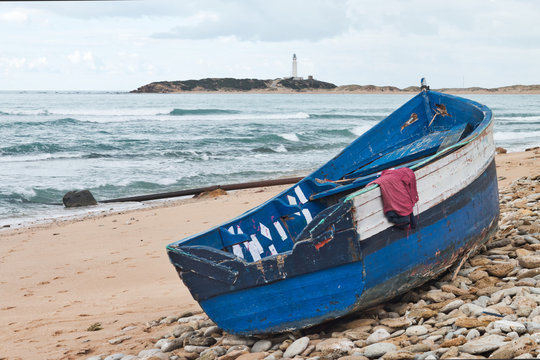 Old boat arrives with immigrants from Africa to the beach of Los Caños de Meca, Cadiz province, Spain
