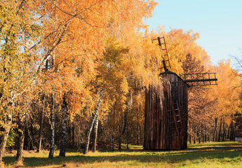 Old wooden windmill in autumn season. Autumn windmill farm panorama.