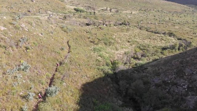 aerial view of a trail runners running down a mountain