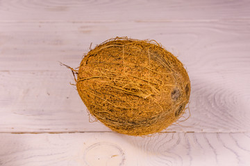 One whole coconut on a wooden table. Top view