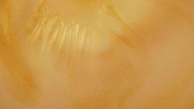 Colorful golden sand organically moves in colorful liquid
