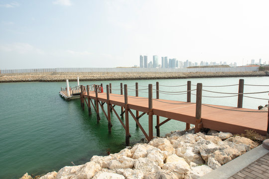 luxury wooden port and skyline of Manama in the Kingdom of Bahrain in middle East during midday - Image