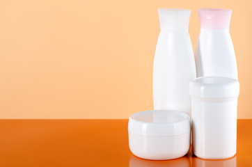 White jar of cream, gel shower, lotion beauty on orange background