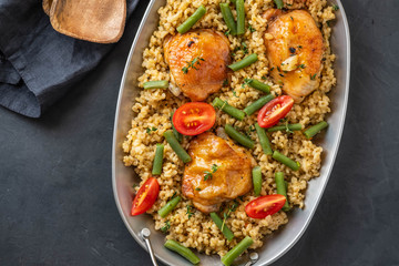 Grilled chicken thighs with bulgur, asparagus beans and tomatoes. Delicious lunch.