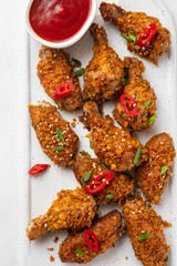 Chicken nuggets with sauce and pepper on a white board. Copy space.