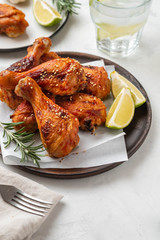 Chicken legs with sauce, rosemary and lime on a white background. Copy space.