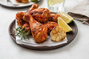 Chicken legs with sauce, rosemary and lime on a white background. Copy space.