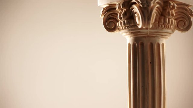 Single ancient corinthian column rotating slowly on bright background