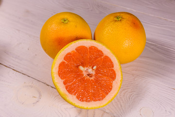 Ripe juicy grapefruit on a white wooden table