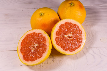Ripe juicy grapefruit on a white wooden table