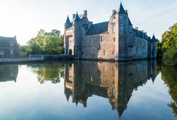 Obraz premium The turrets and drawbridge of the 14th century Chateau de Trecesson in the Forest of Paimpont viewed across the large pool by which it is surrounded