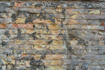 Red and yellowish Brick  wall. Mediterranean style. Aged wall with black moss. Concrete and bricks. 