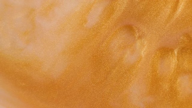 Colorful golden sand organically moves in colorful liquid