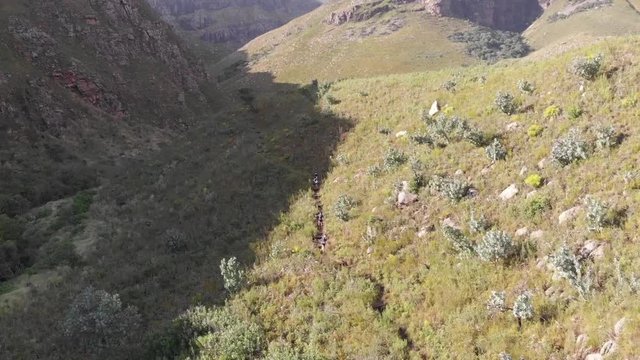 aerial view of a trail runners running down a mountain
