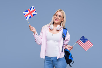 Education, foreign language translator, english, student - smiling blond woman in headphones holding American and British flags. Distance learning