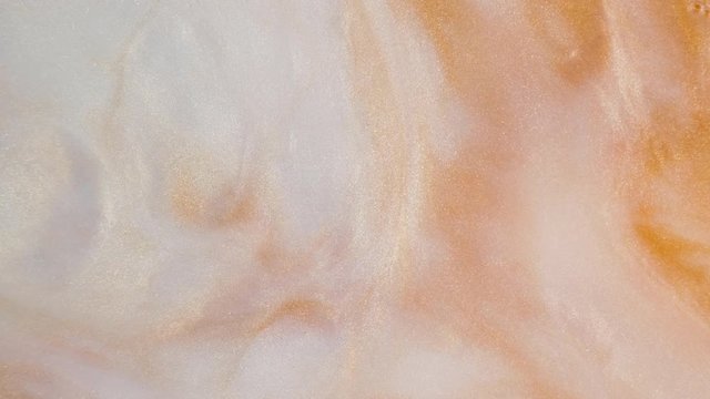 Colorful golden sand organically moves in colorful liquid