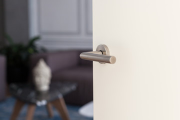 Naklejka premium Open white door with metallic handle. The door to the bedroom