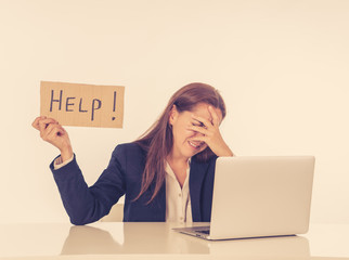 Sad and tired businesswoman holding a help sign feeling helpless and frustrated
