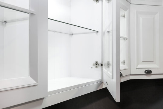 Open door in new clean and white kitchen cabinet