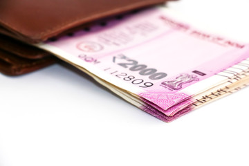 Close up view of wallet with brand new indian 2000 rupees banknotes on white background.