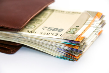 Close up view of wallet with brand new indian 50, 100, 200, 500 rupees banknotes on white background.
