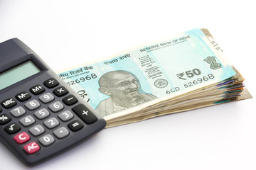 Close up view of calculator over  brand new indian 50, 100, 200, 500 rupees banknoteson white...