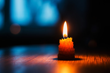 One burning candle in the dark