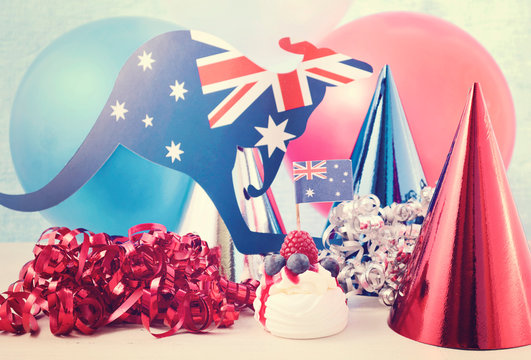 Happy Australia Day Party in red, white and blue theme with mini pavlova and party decorations, with applied vintage wash filter.