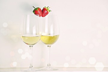 Two glasses of white wine with strawberry heart shape. Valentine's day concept 