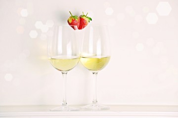 Two glasses of white wine with strawberry heart shape. Valentine's day concept 