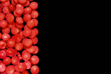 Natural red coral flat beads as red blood cells isolated on a black background