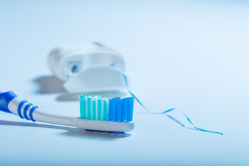 dental floss and toothbrush on an blue background