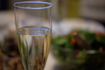 Glass of sparkling wine and light a candle at a festive dinner blurred background