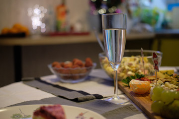 Glass of sparkling wine and light a candle at a festive dinner blurred background