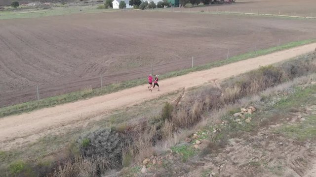 aerial view of two female trail runners on a gravel dirt road