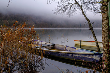 Lac du Val en hiver. Brouillard. Barque en bois sur l'eau. Jura, France.	