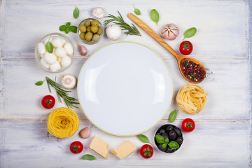 Italian food or ingredients with fresh vegetables, pasta, cheese mozzarella and parmesan, spices. Healthy food background. overhead, horizontal