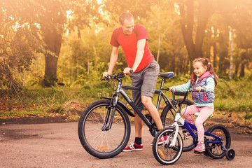 Fototapeta na wymiar Father teaching his daughter to ride a bike