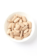 Rhodiola rosea. Golden root, rose root. Herbal pills with healthy medical plant. Healthy supplement on white background. Top view. Copy space. 