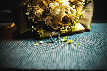 Single engagement silver steel wedding ring with luxury bouquet in the dark blury background