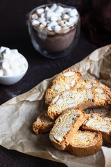 Biscotti or Cantuccini with almond and a glass cup of hot chocolate with marshmallows. Traditional Italian double baked cookies.