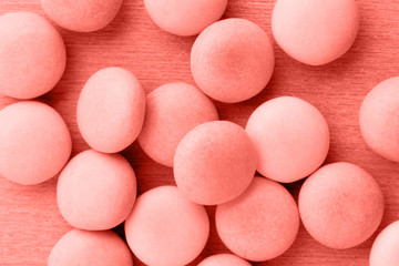 Small round candy living coral pastel background.