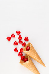 Creative composition for Valentines day with waffle cone, mixed hearts on white background top view. Fashion flat lay.