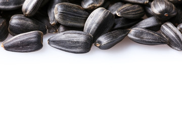Black, natural, roast sunflower seeds isolated on white background. For texture or background