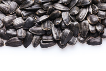 Black, natural, roast sunflower seeds isolated on white background. For texture or background