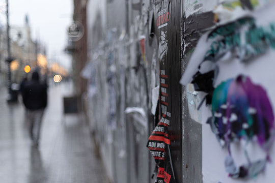 Ulica w zimowe popołudnie z obdrapanym murem pełnym plakatów © Seance_Photo_Sylwia