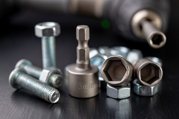 Screws, nuts and keys on a workshop table. Tools and accessories for mechanics.