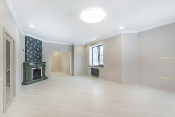 Empty living room interior with fireplace, laminate flooring and doorways