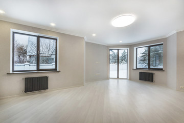 Fototapeta na wymiar Empty living room interior with beige laminate flooring, windows and glass sliding door to the back yard